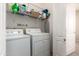 Bright laundry room with washer, dryer, wire shelving, and a view of the interior of the house at 10062 E Isleta Ave, Mesa, AZ 85209