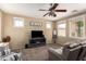 Cozy living room featuring a ceiling fan, plush carpet, and lots of natural light from multiple windows at 10062 E Isleta Ave, Mesa, AZ 85209