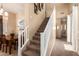 Carpeted staircase with white railing leading to the upper level, adjacent to the dining area and hallway at 10062 E Isleta Ave, Mesa, AZ 85209