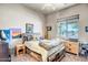 Bedroom with wooden bed frame, large window for natural light, ceiling fan, and artistic decorations at 1032 E Dolores Rd, Phoenix, AZ 85086
