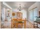 Cozy dining area with natural light, an elegant chandelier, travertine flooring and warm wood accents at 1032 E Dolores Rd, Phoenix, AZ 85086