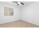 A bright bedroom with tile floors, a window, and a ceiling fan at 10429 W Miami St, Tolleson, AZ 85353