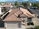 Aerial view of a single-story home with a tile roof, desert landscaping, and a two-car garage at 10429 W Miami St, Tolleson, AZ 85353