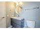 Bathroom with gray vanity, round mirror, and modern fixtures at 11133 W Cameo Dr, Sun City, AZ 85351