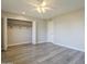 A bright bedroom with grey vinyl flooring, large closet, and ceiling fan at 11133 W Cameo Dr, Sun City, AZ 85351