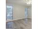 Bright bedroom featuring two windows, wood-look floors, and a ceiling fan at 11133 W Cameo Dr, Sun City, AZ 85351