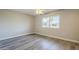 Light-filled bedroom featuring wood-look floors and a large window at 11133 W Cameo Dr, Sun City, AZ 85351
