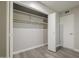 Walk-in closet with shelving, wood-look flooring, and a door to a spare room at 11133 W Cameo Dr, Sun City, AZ 85351