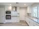 Bright kitchen featuring stainless steel appliances, white cabinetry and ample counter space at 11133 W Cameo Dr, Sun City, AZ 85351