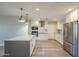 Bright kitchen featuring stainless steel appliances, a large island and modern lighting at 11133 W Cameo Dr, Sun City, AZ 85351