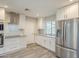 Modern kitchen with stainless steel appliances, white cabinetry, and ample counter space at 11133 W Cameo Dr, Sun City, AZ 85351