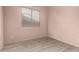 Bedroom with neutral walls, wood-look flooring, and a window with horizontal blinds at 11622 W Palm Brook Dr, Avondale, AZ 85392