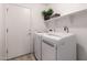 Well-lit laundry room with front-load washer and dryer, shelving and a door at 11622 W Palm Brook Dr, Avondale, AZ 85392