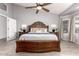 Spacious main bedroom with ceiling fan, a large bed with wooden frame and decorative lamps at 11622 W Palm Brook Dr, Avondale, AZ 85392