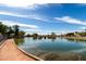 Picturesque view of the community pond with a walking path, perfect for leisurely strolls and enjoying nature at 11622 W Palm Brook Dr, Avondale, AZ 85392