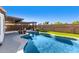 A refreshing pool with a tanning ledge, lush turf, and a charming pergola offers an outdoor living retreat at 11622 W Palm Brook Dr, Avondale, AZ 85392