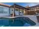 A beautiful freeform pool is surrounded by lush landscaping and a covered patio at 11622 W Palm Brook Dr, Avondale, AZ 85392