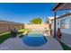 The backyard features a freeform pool and spa, surrounded by artificial turf and lush landscaping at 11622 W Palm Brook Dr, Avondale, AZ 85392
