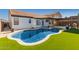 Private backyard oasis with a pool, synthetic grass and covered patio for relaxing at 11622 W Palm Brook Dr, Avondale, AZ 85392