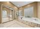 Bright bathroom boasts double vanity, glass shower, and soaking tub with decorative tile surround at 11816 E Terra Dr, Scottsdale, AZ 85259