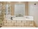 Bright bathroom boasts a tile-surround tub under a glass block window at 11816 E Terra Dr, Scottsdale, AZ 85259