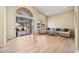 Spacious living area with blonde wood floors, large windows, and glass door to the outside at 11816 E Terra Dr, Scottsdale, AZ 85259