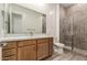 Modern bathroom featuring a wood vanity, quartz countertop, and glass enclosed tiled shower at 13619 W Hackamore Dr, Peoria, AZ 85383