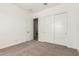 Bedroom featuring neutral carpet and white closet doors, with an open entry to another room at 13619 W Hackamore Dr, Peoria, AZ 85383