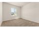 A bright bedroom features neutral carpet and a window bringing in natural light at 13619 W Hackamore Dr, Peoria, AZ 85383