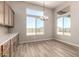 Dining area featuring wood flooring, a modern chandelier, and a view of the back yard at 13619 W Hackamore Dr, Peoria, AZ 85383