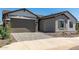 Exterior shot of a house featuring a two car garage, rock landscaping, and neutral toned exterior at 13619 W Hackamore Dr, Peoria, AZ 85383