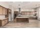 Kitchen features stainless steel appliances, wood cabinets, tile backsplash, and large island at 13619 W Hackamore Dr, Peoria, AZ 85383