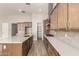 Kitchen with stainless steel appliances, wood cabinets, tile backsplash, and island at 13619 W Hackamore Dr, Peoria, AZ 85383