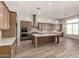 Kitchen features stainless steel appliances, wood cabinets, tile backsplash, and large island at 13619 W Hackamore Dr, Peoria, AZ 85383