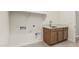 Bright laundry room with hexagon tile flooring, a utility sink and connections for a washer and dryer at 13619 W Hackamore Dr, Peoria, AZ 85383