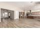 Open-concept living room features wood flooring, a kitchen, and an entry way at 13619 W Hackamore Dr, Peoria, AZ 85383