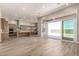 Open-concept living room with wood flooring, large sliding glass doors, and kitchen at 13619 W Hackamore Dr, Peoria, AZ 85383
