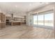 Open-concept living room with wood flooring, large sliding glass doors, and kitchen at 13619 W Hackamore Dr, Peoria, AZ 85383