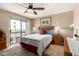 Bright bedroom with sliding glass doors to balcony, ceiling fan, and warm, inviting decor at 1401 E Puget Ave # 10, Phoenix, AZ 85020