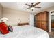 Bright bedroom with neutral walls, a ceiling fan, and a large wooden armoire at 1401 E Puget Ave # 10, Phoenix, AZ 85020