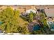 An aerial shot showcases the property's backyard, featuring a pool, spa, grass, and mature trees at 15806 N 45Th Pl, Phoenix, AZ 85032
