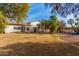 Expansive backyard featuring a pool, mature trees, covered patio, and ample grass at 15806 N 45Th Pl, Phoenix, AZ 85032
