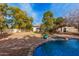 Backyard view showcasing a large pool with stone accents and mature landscaping at 15806 N 45Th Pl, Phoenix, AZ 85032