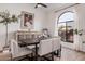 Bright dining room features an artful cabinet, rustic wood table, and large arched window with white curtains at 15806 N 45Th Pl, Phoenix, AZ 85032