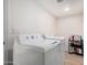 Practical laundry room equipped with a washing machine, dryer, and storage shelves at 15806 N 45Th Pl, Phoenix, AZ 85032