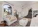 Cozy living room featuring a large arched window, comfortable seating, and stairs at 15806 N 45Th Pl, Phoenix, AZ 85032
