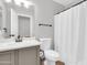 Neutral bathroom with a single sink vanity, toilet, and a shower/tub combination with white shower curtain at 1858 S Ocotillo Dr, Apache Junction, AZ 85120