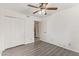 Bedroom with wood-look flooring, ceiling fan, and closet with white sliding doors at 1905 E University Dr # 139, Tempe, AZ 85288
