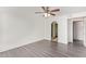 A bedroom featuring wood-look flooring, a ceiling fan, and a doorway with an arched entrance at 1905 E University Dr # 139, Tempe, AZ 85288