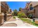 Charming condo exterior with a well-maintained walkway, lush landscaping, and vibrant desert foliage at 1905 E University Dr # 139, Tempe, AZ 85288
